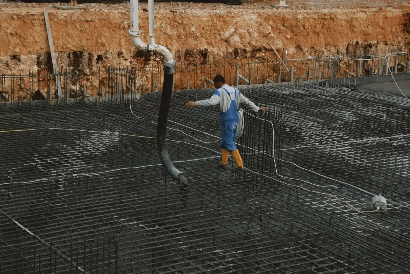A tied rebar mat laid out over a prepared sub-base before the pour