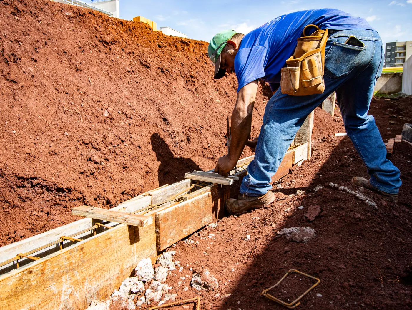 A carpenter setting wood formwork and rebar before a concrete pour