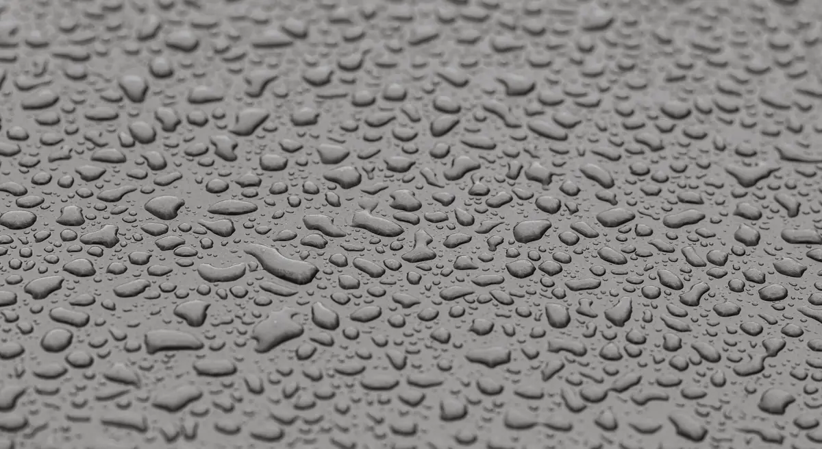 Water beading on a sealed gray concrete surface